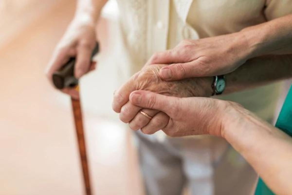 Persona sosteniendo la mano de una persona adulta mayor. Foto: Especial