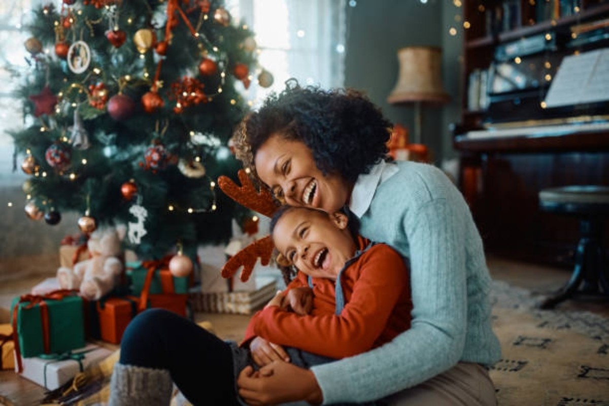 Madre e hijo enfrente de un árbol de Navidad Foto. Pexels