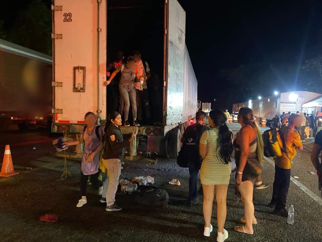 Migrantes siendo bajados del trailer 
